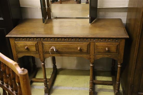 A carved and panelled oak wardrobe fitted two doors with matching compactum and dressing table, wardrobe W.104cm, D.55cm, H.178cm